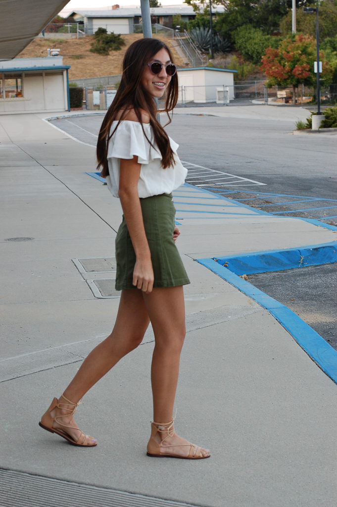 Off the shoulder top green skirt smiling