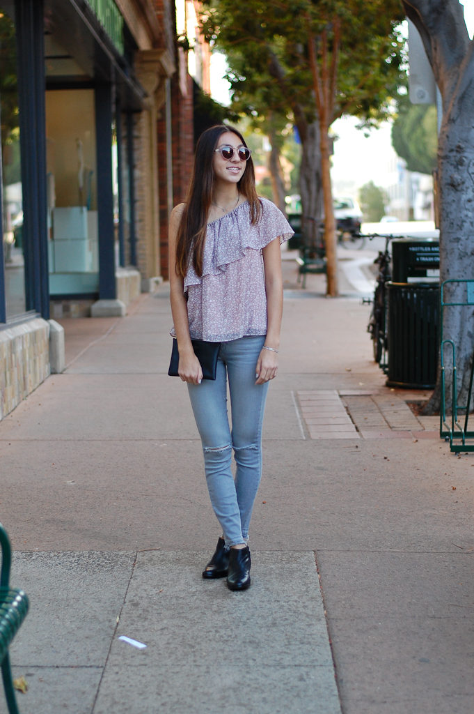one shoulder gray jeans crossed